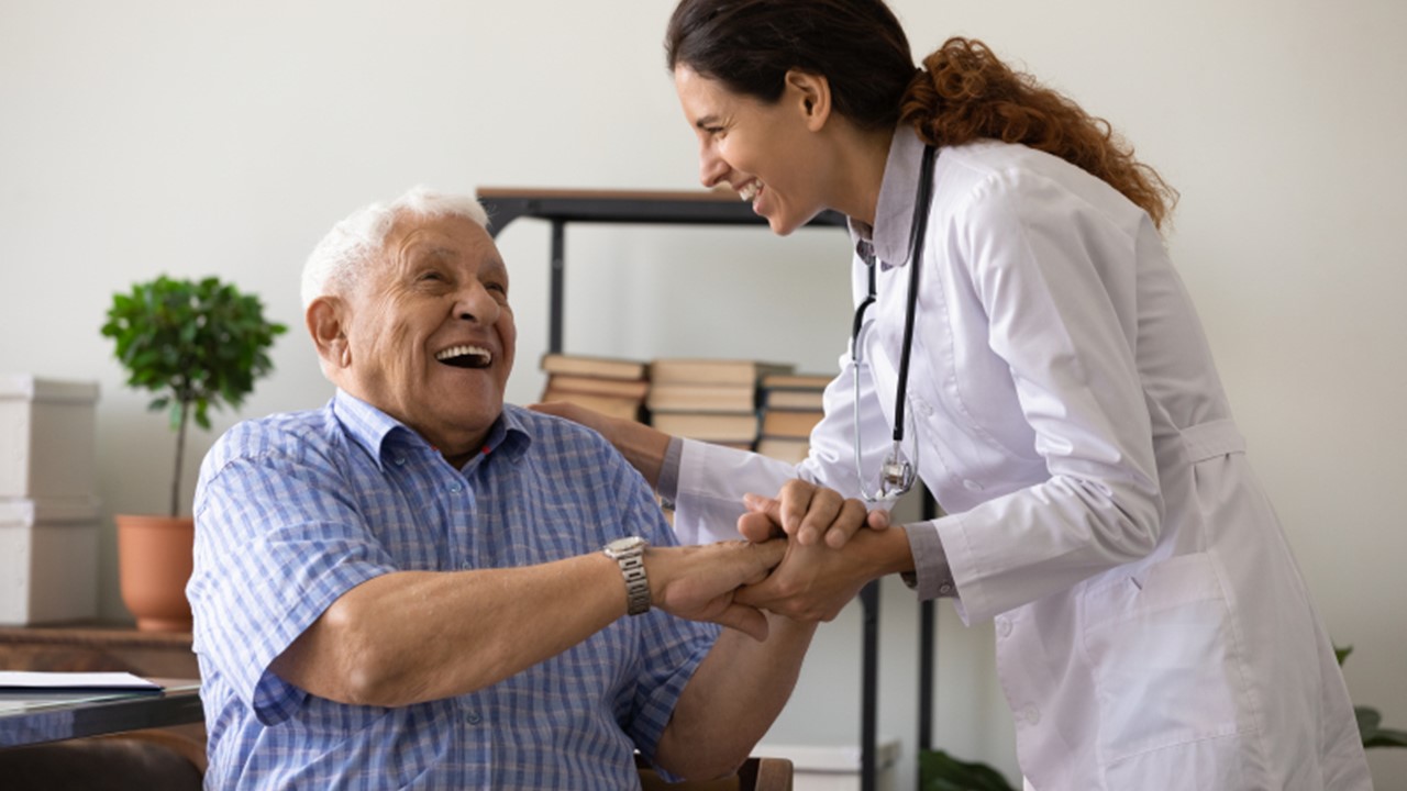 Bild som visar en sjuksköterska som pratar med en äldre man